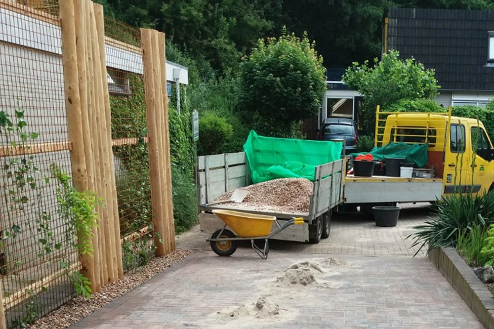 Oprit met afscheiding van douglas, betongaas en klimplanten